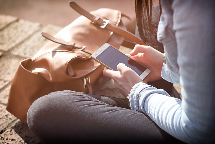 [Translate to German:] Woman typing on Smartphone